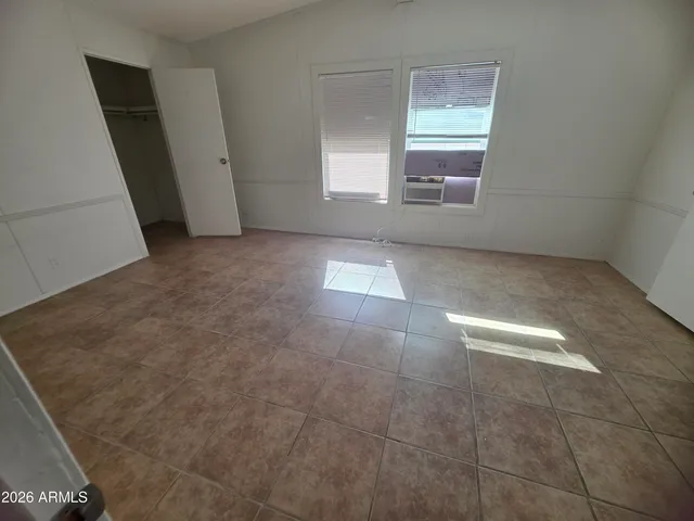 an empty room with a fireplace and windows