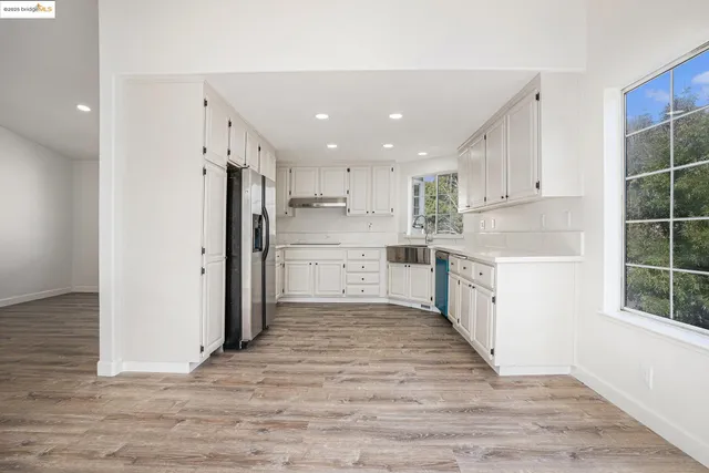 a large kitchen with a refrigerator and window