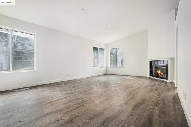 a view of empty room with wooden floor and fireplace