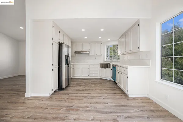 a large kitchen with a refrigerator and window