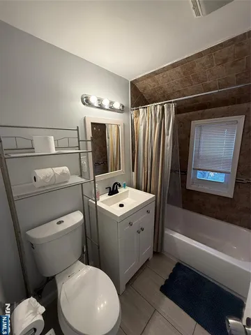 a bathroom with a toilet sink vanity tub and mirror