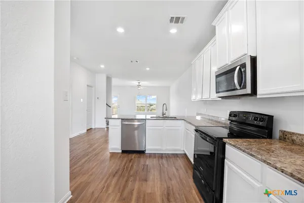 a kitchen with a sink and steel appliances