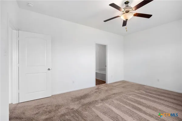 an empty room with a window and a fan