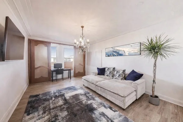 a living room with furniture and a chandelier