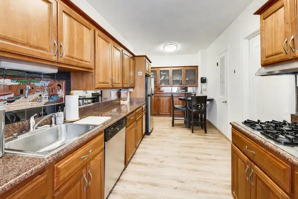 a kitchen with stainless steel appliances granite countertop a sink stove and refrigerator