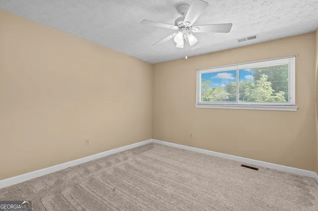 a view of an house with backyard and trees