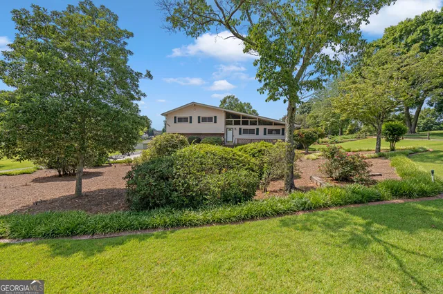 a front view of a house with a yard and potted plants
