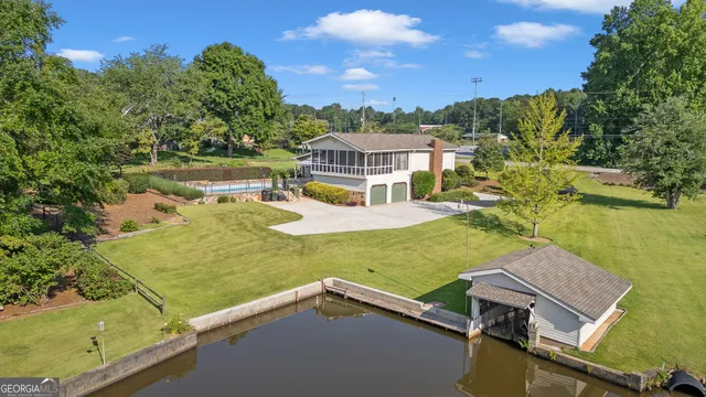 an aerial view of a house with swimming pool and lake view