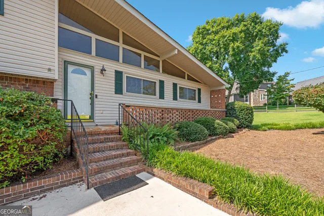a view of empty room with wooden floor and ceiling fan