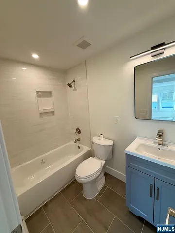 a bathroom with a double vanity sink toilet mirror and bathtub