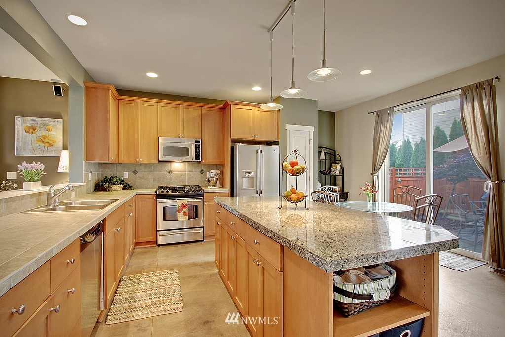 559 Alpine Ridge Place Northwest Issaquah, WA 98027 - Photo 3 of 15 a large kitchen with kitchen island a large counter top space appliances and a center island
