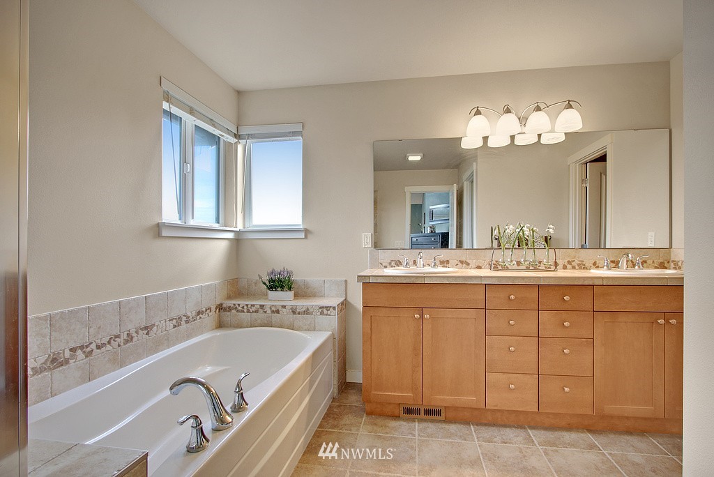 559 Alpine Ridge Place Northwest Issaquah, WA 98027 - Photo 8 of 15 a bathroom with a tub a double vanity sink and a mirror