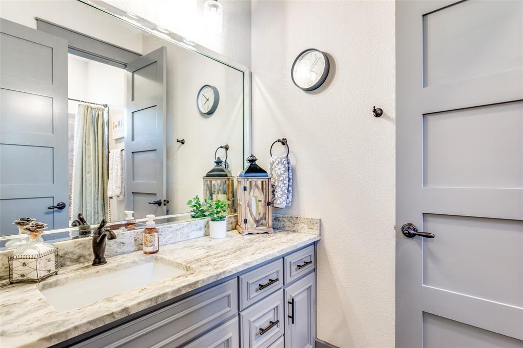 216 Deer Glade Court Azle, TX 76020 - Photo 32 of 40 a bathroom with a granite countertop sink and a mirror