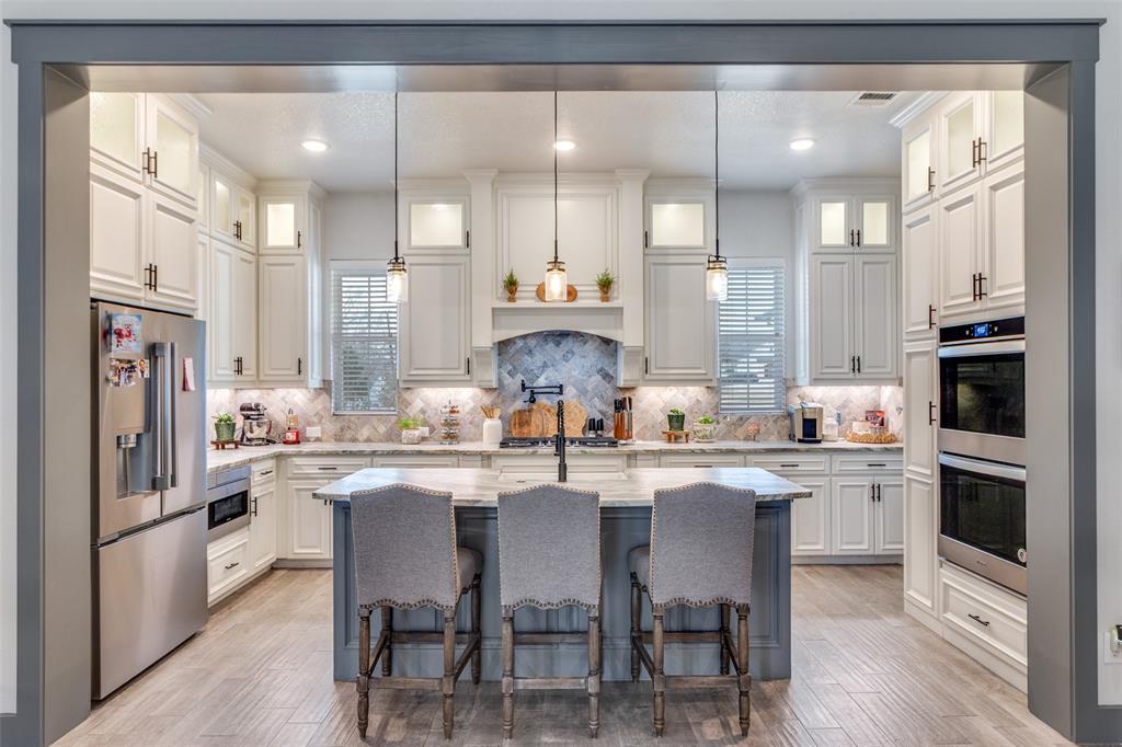 216 Deer Glade Court Azle, TX 76020 - Photo 9 of 40 a kitchen with stainless steel appliances granite countertop a stove top oven a sink refrigerator and cabinets