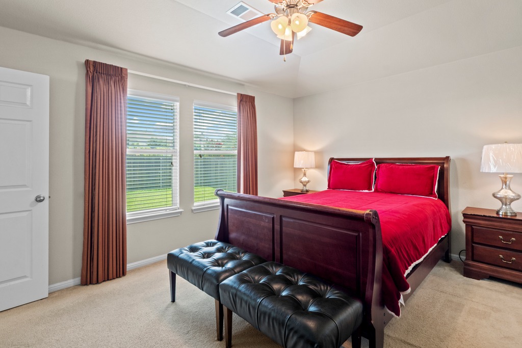12008 Lansdowne Road Austin, TX 78754 - Photo 17 of 29 A well-lit bedroom features plush carpeting and a vaulted ceiling, providing a serene retreat.