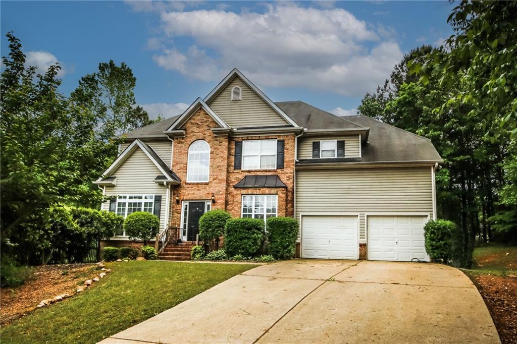 64 Creekside Way Hiram, GA 30141 - Photo 1 of 1 a front view of a house with a garden and trees