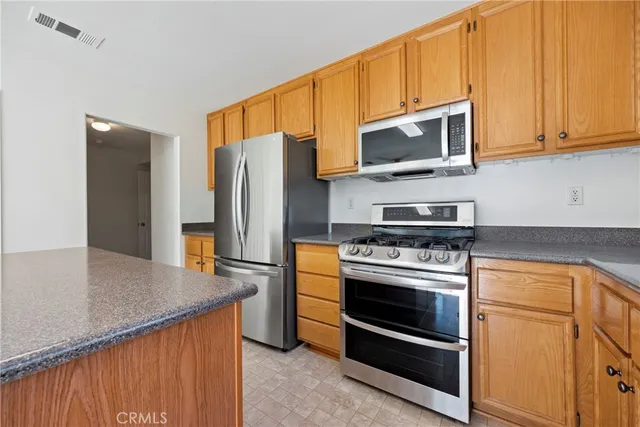 a kitchen with stainless steel appliances granite countertop a stove microwave and refrigerator
