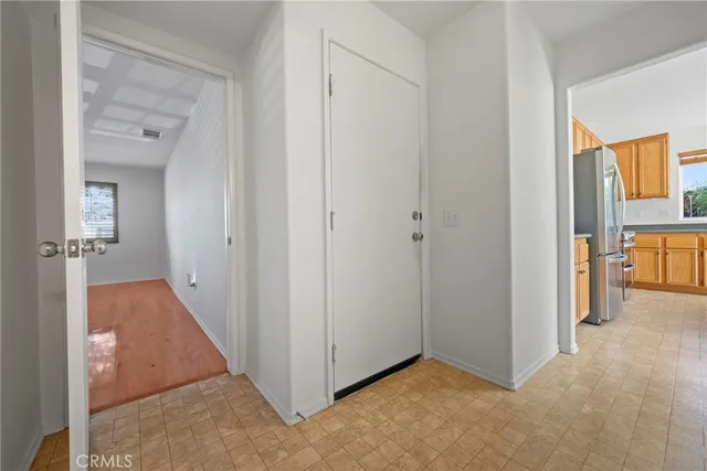 a view of a livingroom with wooden floor and a bathroom