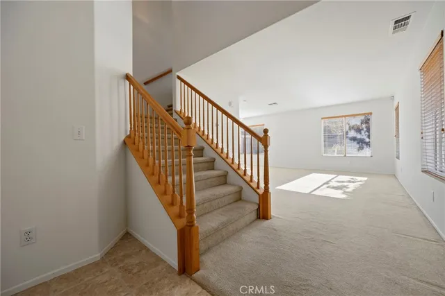 a view of staircase with wooden floor and white walls