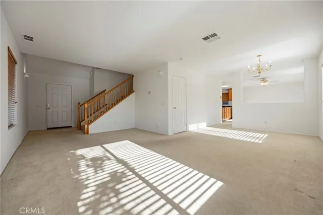 a view of an empty room with stairs and ventilation