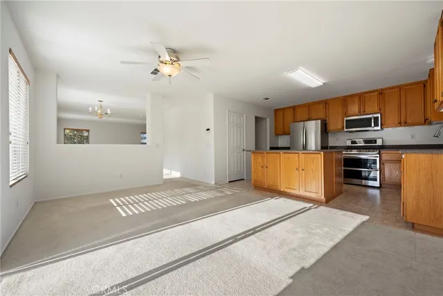 a living room with stainless steel appliances kitchen island furniture and a kitchen view