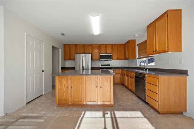 a kitchen with stainless steel appliances granite countertop a stove a sink and a refrigerator