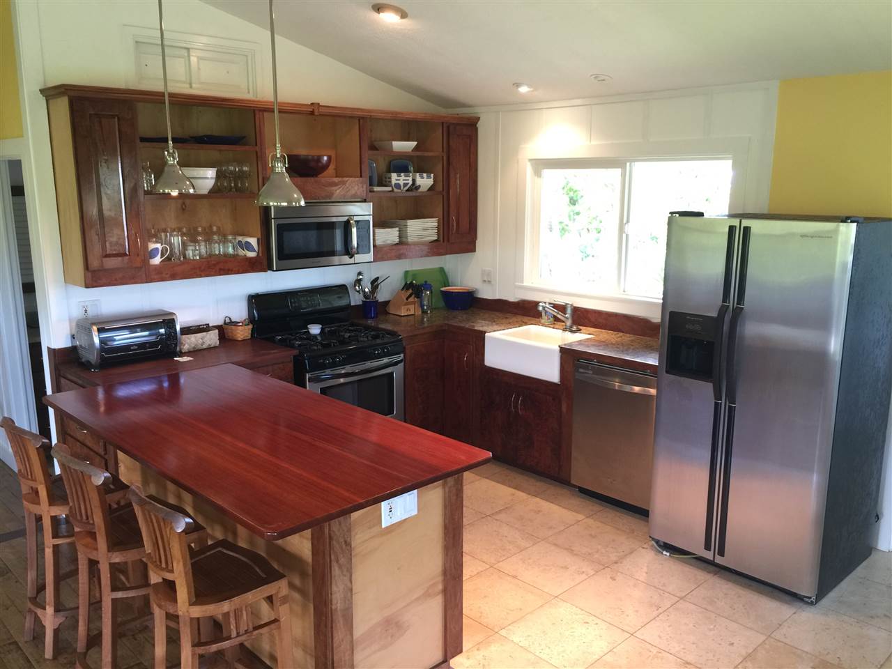 1061 Kokomo Road Haiku, HI 96708 - Photo 22 of 30 a kitchen with stainless steel appliances kitchen island granite countertop a refrigerator a stove a sink and dishwasher