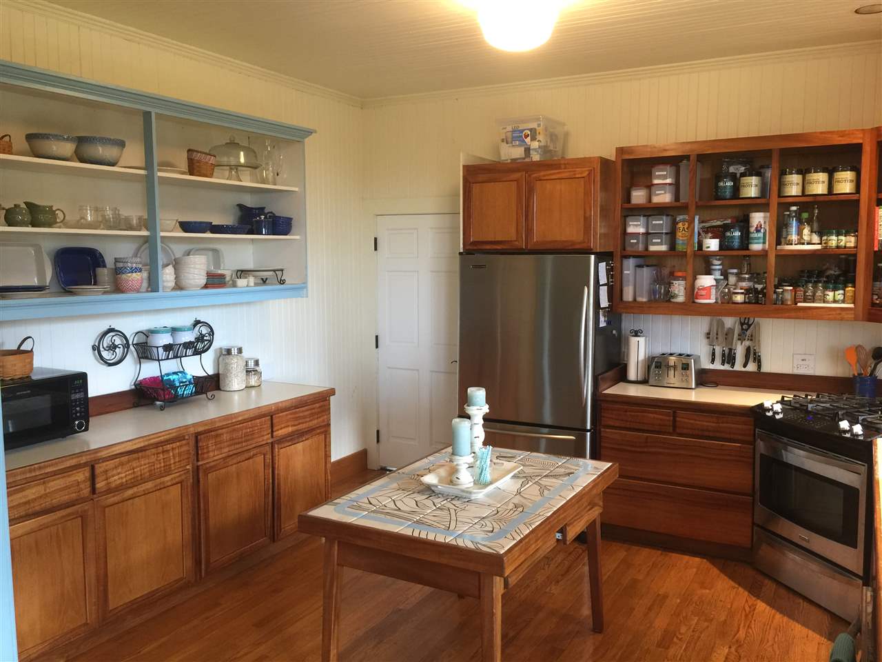 1061 Kokomo Road Haiku, HI 96708 - Photo 5 of 30 a kitchen with stainless steel appliances granite countertop a refrigerator and a stove top oven