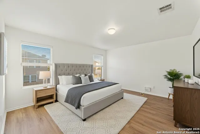 a living room with a bed furniture and a potted plant