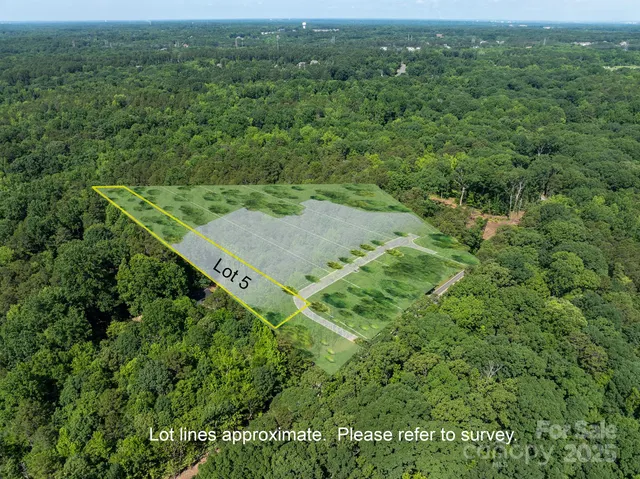 an aerial view of residential house with outdoor space and trees all around