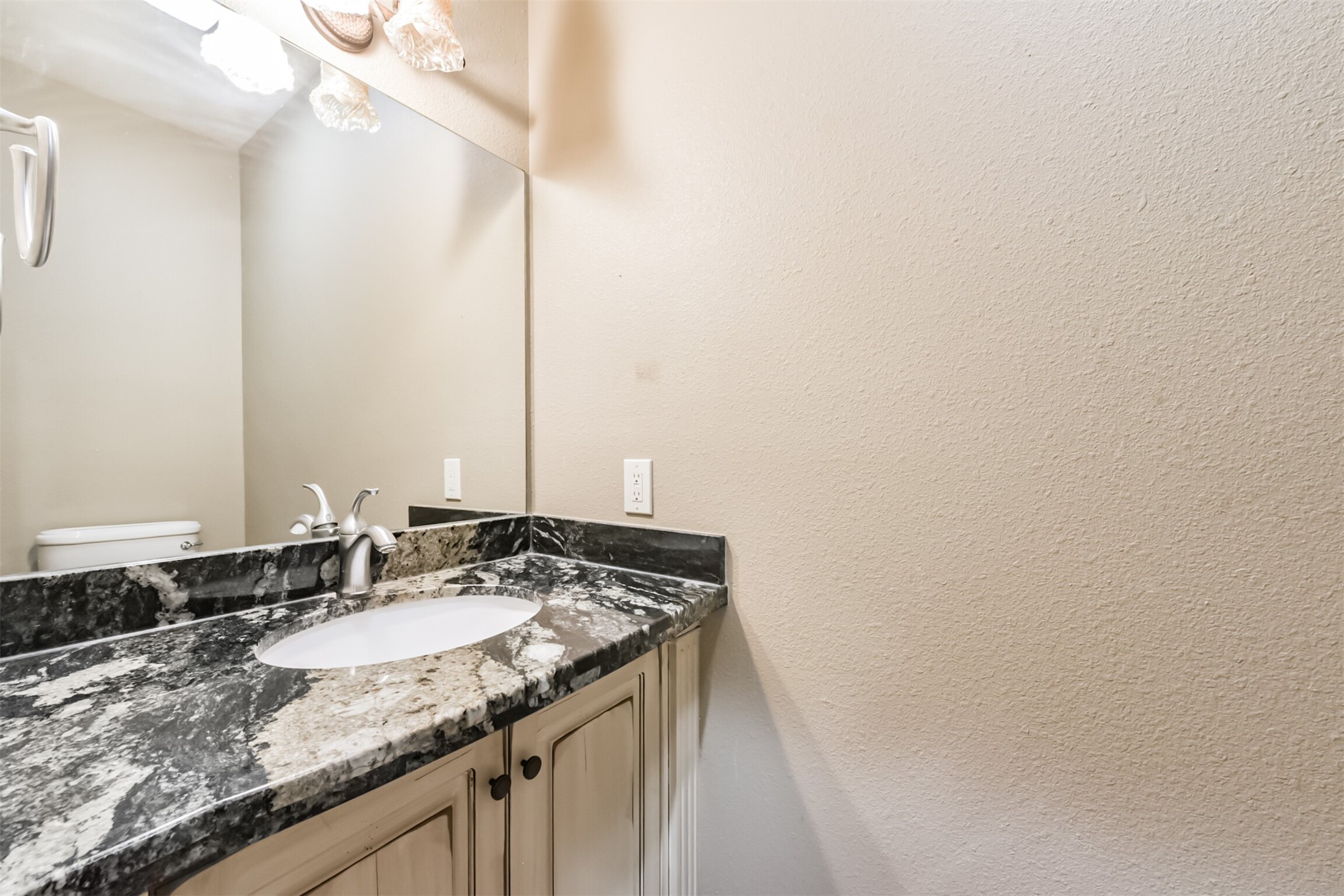 46 Deer Ridge Cleveland, TX 77327 - Photo 16 of 40 a bathroom with a granite countertop sink and a mirror