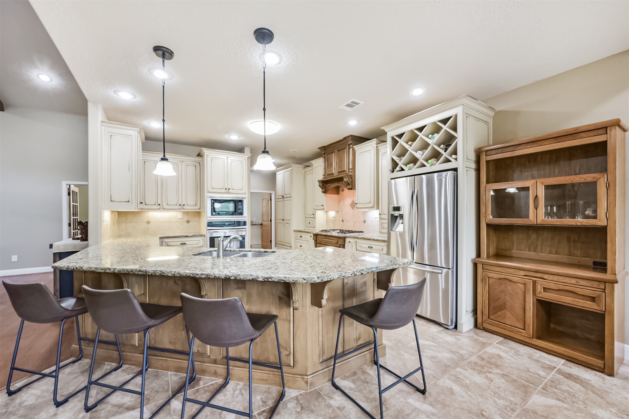 46 Deer Ridge Cleveland, TX 77327 - Photo 9 of 40 a kitchen with stainless steel appliances kitchen island granite countertop a dining table chairs and white cabinets