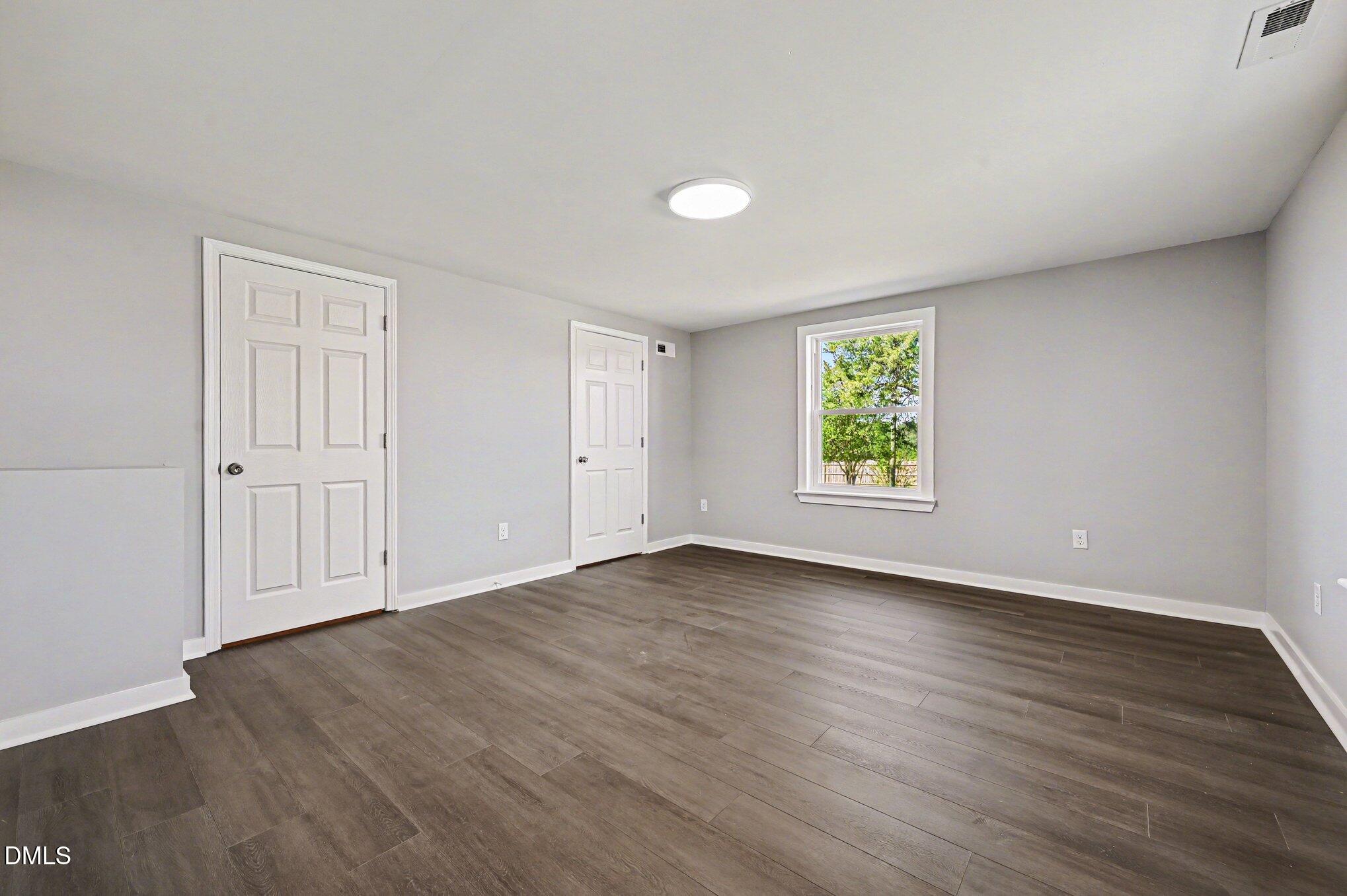 1325 Charlie Carr Road Roxboro, NC 27574 - Photo 22 of 31 an empty room with wooden floor and window