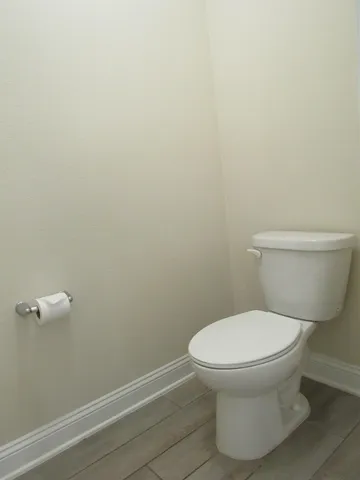 a white toilet sitting next to a white wall