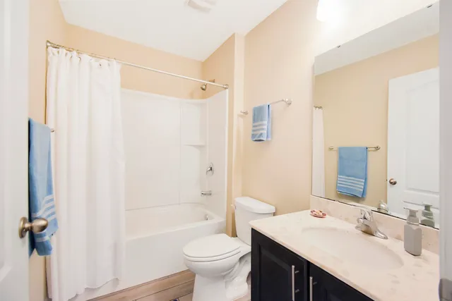 a bathroom with a sink a toilet a mirror and shower