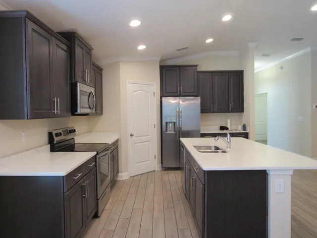 a kitchen with a sink a stove a refrigerator and a oven