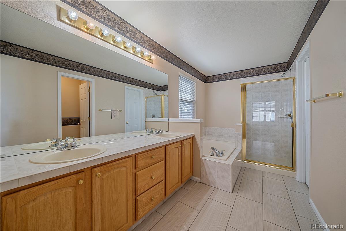 6310 Trailhead Road Highlands Ranch, CO 80130 - Photo 14 of 23 a spacious bathroom with a double vanity sink a toilet and a mirror