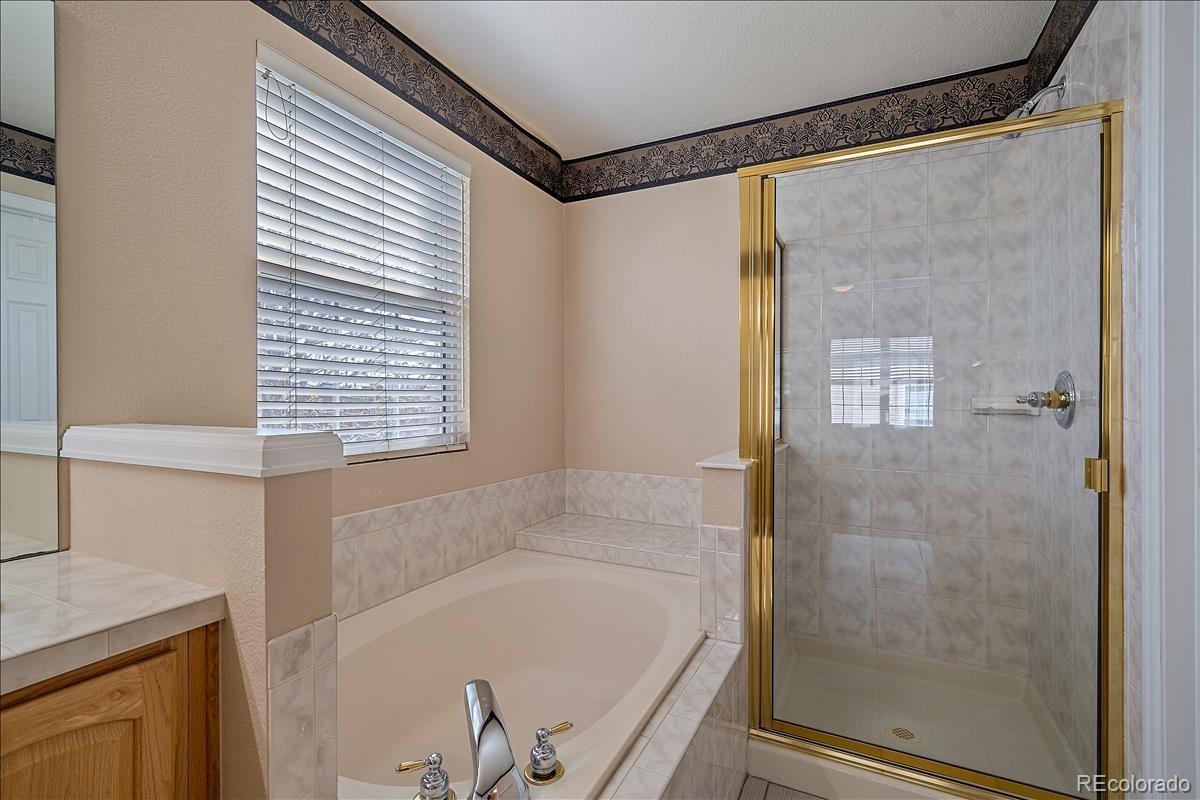 6310 Trailhead Road Highlands Ranch, CO 80130 - Photo 15 of 23 a bathroom with a bathtub and a shower