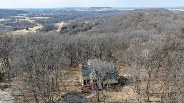 a kitchen with stainless steel appliances granite countertop a stove a refrigerator a kitchen island a dining table and chairs with wooden floor