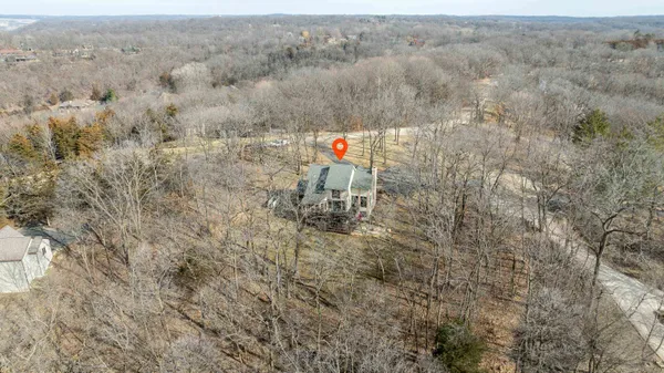 a kitchen with stainless steel appliances granite countertop a refrigerator a sink dishwasher and wooden cabinets with wooden floor