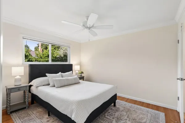 a bedroom with a bed and a chandelier fan