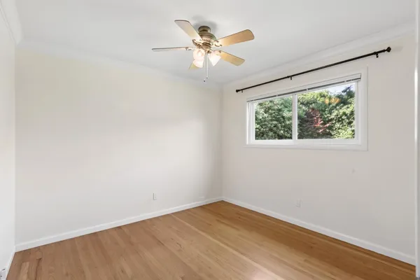 a view of a room with wooden floor and a ceiling fan
