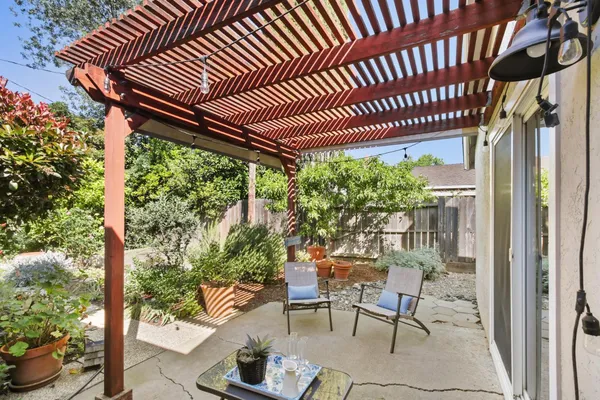 a porch with a table and chairs and potted plants