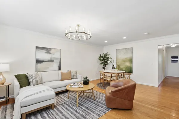 a living room with furniture a chandelier and a window