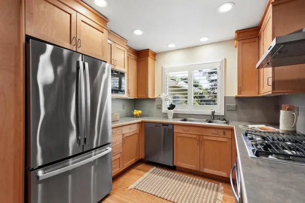 a kitchen with stainless steel appliances granite countertop a refrigerator sink and stove