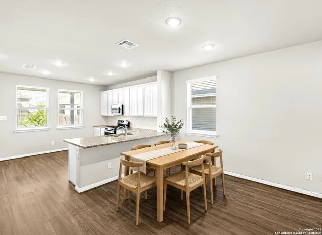 a kitchen with stainless steel appliances granite countertop a sink stove and wooden floor