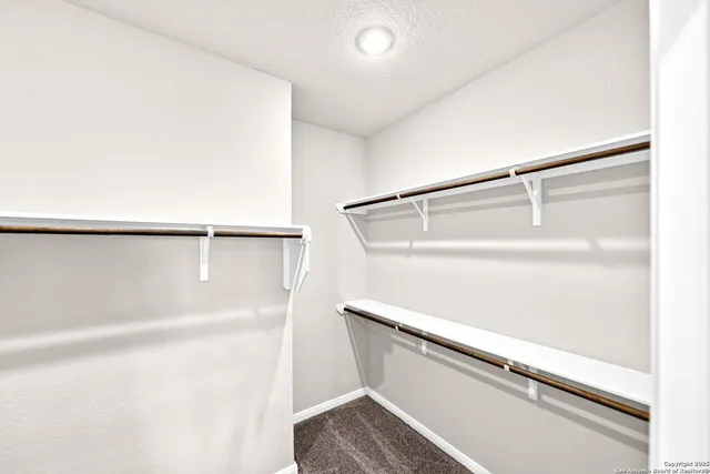 a view of walk in closet with empty racks