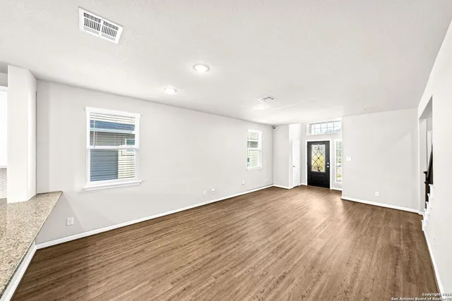 a kitchen with granite countertop kitchen island wooden floor center island and stainless steel appliances