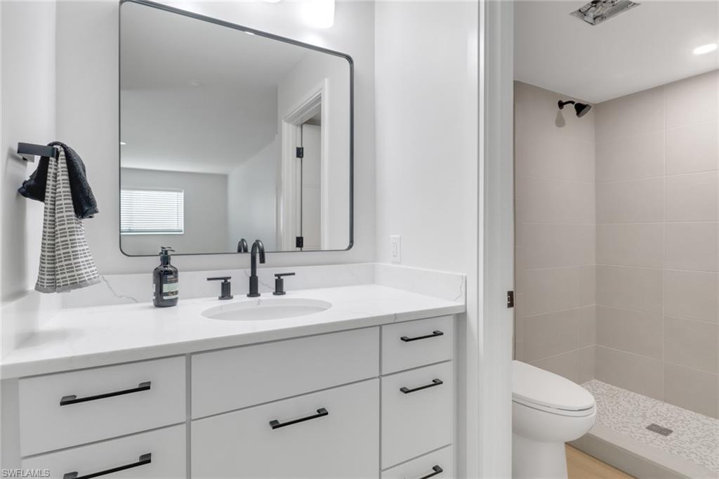 4150 Crayton Road, Unit B3 Naples, FL 34103 - Photo 11 of 19 a bathroom with a double vanity sink toilet and a mirror