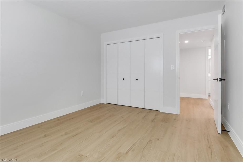 4150 Crayton Road, Unit B3 Naples, FL 34103 - Photo 12 of 19 a view of an empty room with wooden floor and a bathroom